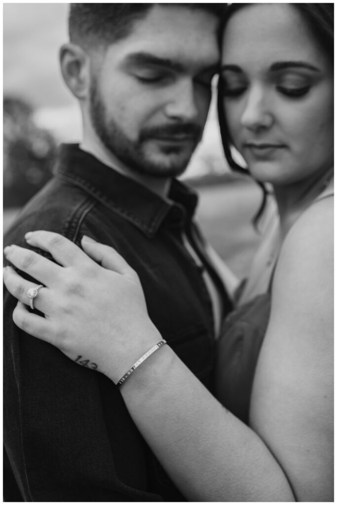 Tight black and white engagement portrait embracing by Coastal Chic Studios