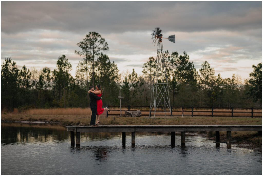 Wide image of an Engagement portrait on a dock by Coastal Chic Studios