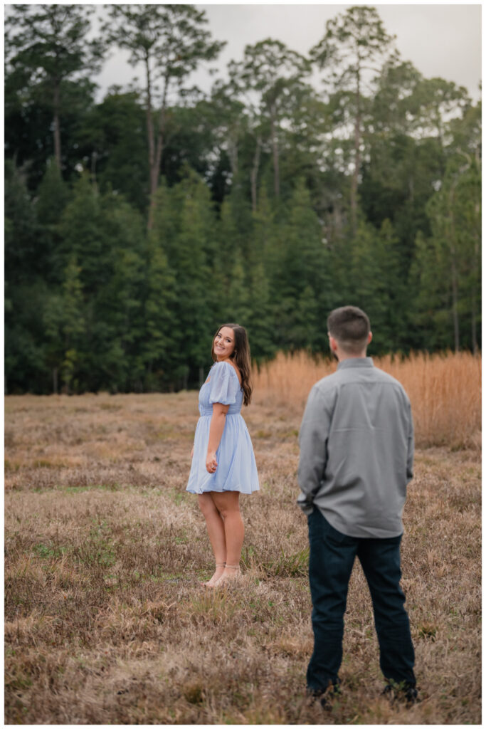 image of an Engagement portrait in a field by Coastal Chic Studios
